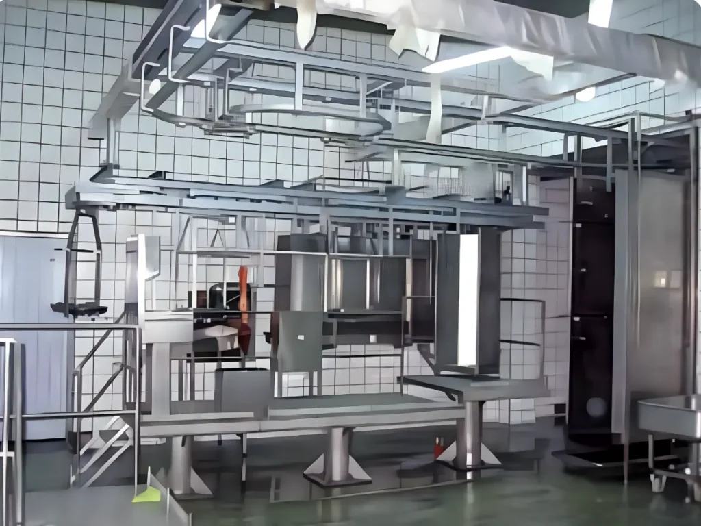 Podesty robocze, kolejka transportowa i konstrukcja ze stali nierdzewnej w strefie czystej zakładu mięsnego.